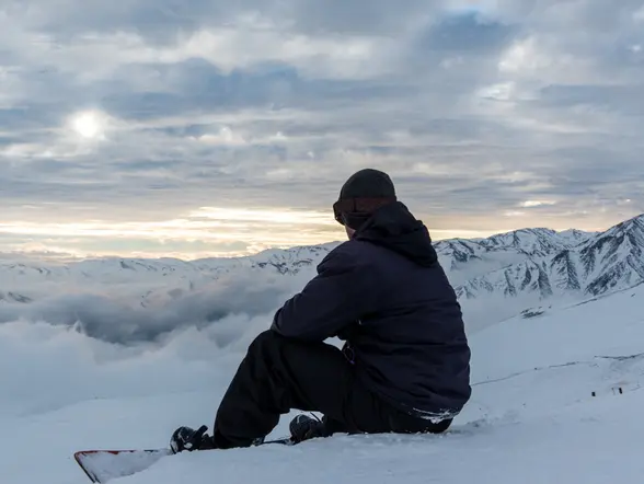 Chico sentando contemplado las vistas de las montañas.