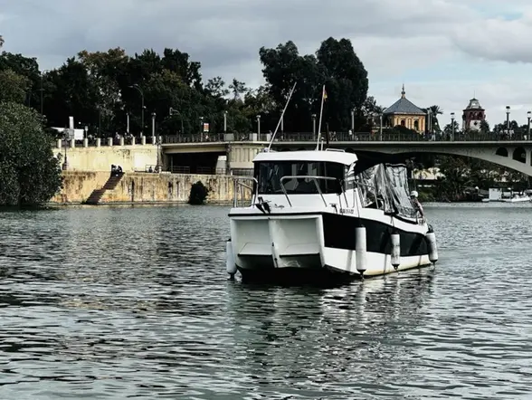 El barco navega suavemente, ofreciendo una vista única del Guadalquivir.