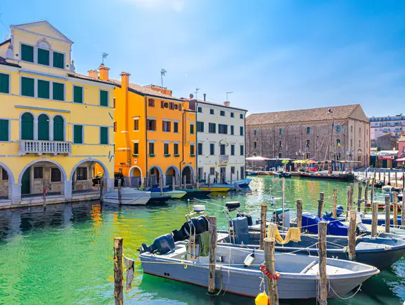 Barcos tradicionales atracados frente a la arquitectura típica de la ciudad.