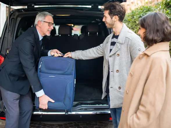 El conductor ayuda con la maleta a una pareja en el Aeropuerto Internacional Rafel Núñez.