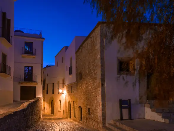 Calles empedradas de Ibiza por la noche, creando un ambiente mágico.