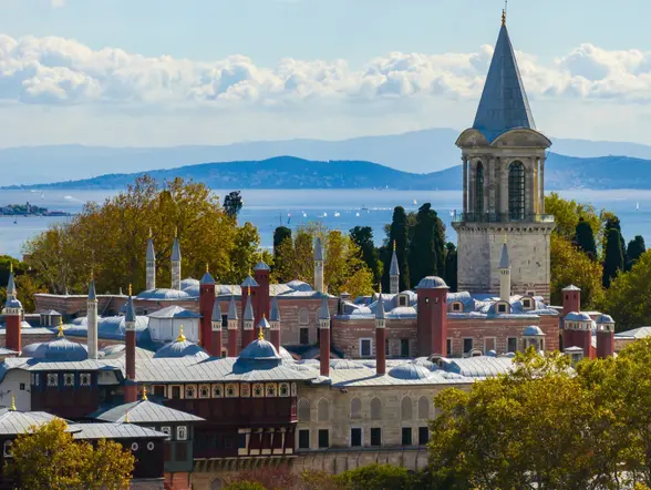 Fachada del Palacio de Topkapi en Estambul, rodeado de jardines y arquitectura otomana clásica.