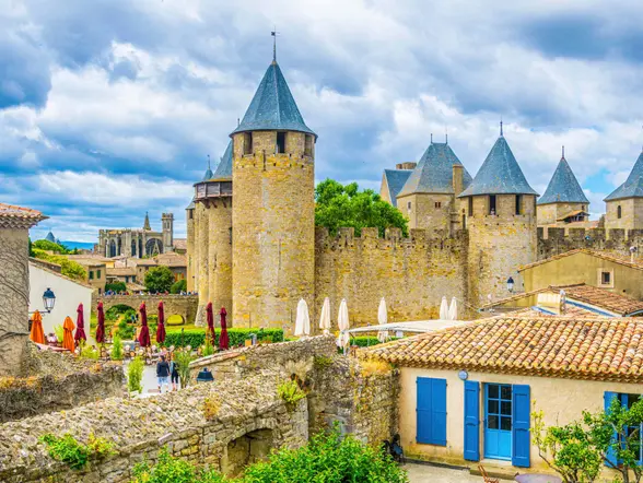 Calles y terrazas dentro de la ciudadela de Carcasona, con vistas a las murallas y a la Basílica de San Nazario.