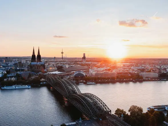Catedral de Colonia y puente Hohenzollern sobre el río Rin durante el atardecer.