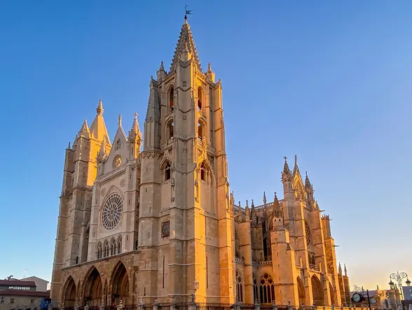 Catedral de León al atardecer, edificio gótico francés conocido como Pulchra Leonina, bajo un cielo azul despejado.