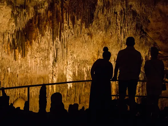 Siluetas de personas observando las Cuevas del Drach, Mallorca