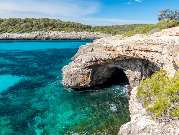 Acantilados y cueva marina sobre aguas en Cala Mondragó, Mallorca