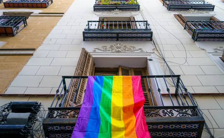 Fachada de un edificio con la bandera que representa los derechos LGTBI.