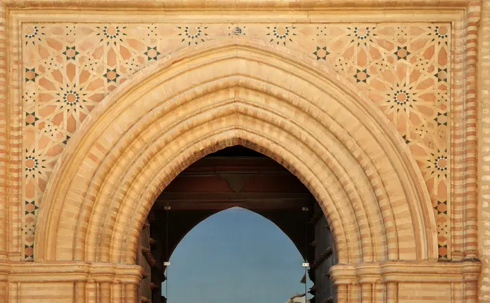 Vista de los elementos de arte mudéjar en el Monasterio de San Isidoro del Campo, con intricados motivos decorativos que combinan influencias cristianas y musulmanas.