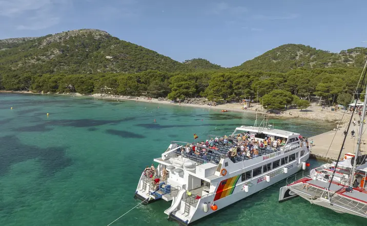 Atracado en la orilla de Formentor, el barco invita a los pasajeros a zambullirse en sus aguas cristalinas y disfrutar de un baño refrescante.