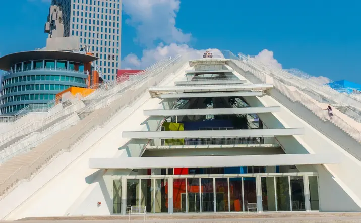 Vista de la Pirámide de Tirana, destacando su estructura inconfundible y su diseño futurista, rodeada de la ciudad.