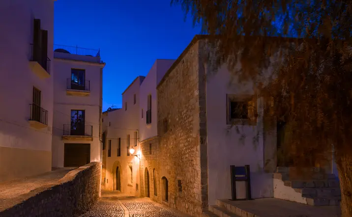Calles empedradas de Ibiza por la noche, creando un ambiente mágico.