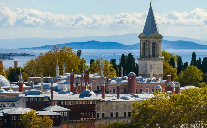 Fachada del Palacio de Topkapi en Estambul, rodeado de jardines y arquitectura otomana clásica.
