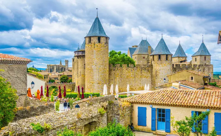 Calles y terrazas dentro de la ciudadela de Carcasona, con vistas a las murallas y a la Basílica de San Nazario.