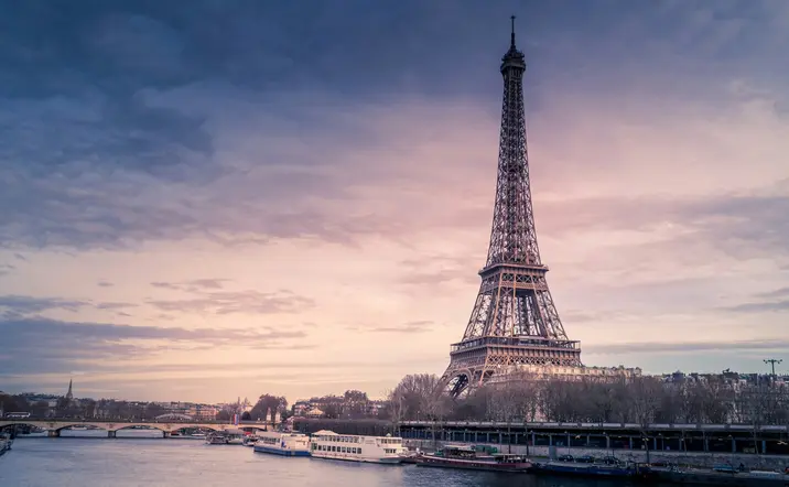 Torre Eiffel en París, Francia, destacando su estructura icónica contra un cielo azul.