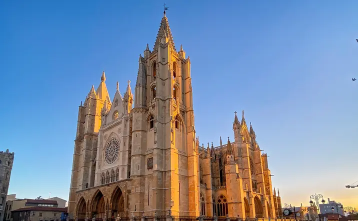 Catedral de León al atardecer, edificio gótico francés conocido como Pulchra Leonina, bajo un cielo azul despejado.