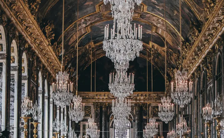 El Salón de los Espejos en Versalles, con sus lujosos espejos y candelabros brillantes, refleja la opulencia del palacio.
