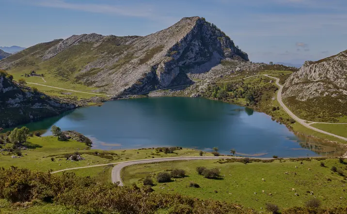 Vista aérea del Lago Enol, Lagos de Covadonga en Picos de Europa, Asturias, con montañas y carretera.